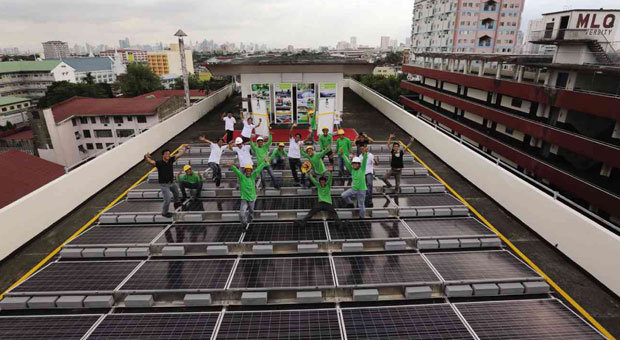 HERE COMES THE SUN  Solar power technicians celebrate the inauguration of their project on the rooftop of the MLQU Monzon Hall on Wednesday. JOAN BONDOC 