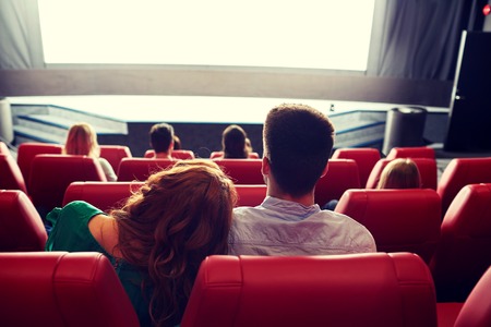 51333513 - cinema, entertainment, leisure and people concept - happy, couple watching movie in theater from back