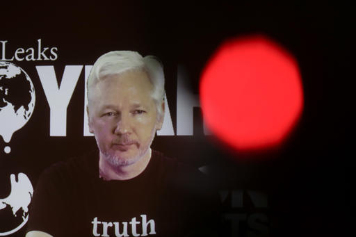 In this photo taken with a red television camera control light in the foreground, WikiLeaks founder Julian Assange participates via video link at a news conference marking the 10th anniversary of the secrecy-spilling group in Berlin, Germany, Tuesday, Oct. 4, 2016. Assange said that WikiLeaks plans to start a series of publications this week, but wouldn’t specify the timing and subject. (AP Photo/Markus Schreiber)