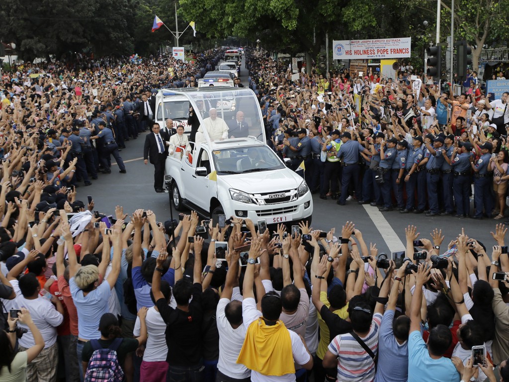 In this Friday, Jan. 16, 2015 file photo, Filipino Catholics take photos, using their phones and tablets, of Pope Francis aboard his Popemobile as his motorcade passes by on the way to another "Meeting With Families" at the Mall of Asia Arena in Manila, Philippines. AP 