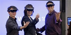 Microsoft's Joe Belfiore, from left, Alex Kipman, and Terry Myerson playfully pose for a photo while wearing "Hololens" devices following an event demonstrating new features of Windows 10 at the company's headquarters on Wednesday, Jan. 21, 2015, in Redmond, Wash. Executives demonstrated how they said the new Windows is designed to provide a more consistent experience and a common platform for software apps on different devices, from personal computers to tablets, smartphones and even the company's Xbox gaming console. (AP Photo/Elaine Thompson)