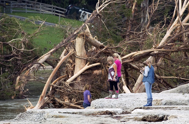 From left to right, Cara Hewitt, Linda Balas, Kathy Bullard and Doreen Crow look at the spot in Wimberley, Texas, on Thursday May 28, 2015, where eight of their friends from Corpus Christi were swept away in a flood. (Jay Janner/Austin American-Statesman via AP)  AUSTIN CHRONICLE OUT, COMMUNITY IMPACT OUT, INTERNET AND TV MUST CREDIT PHOTOGRAPHER AND STATESMAN.COM, MAGAZINES OUT