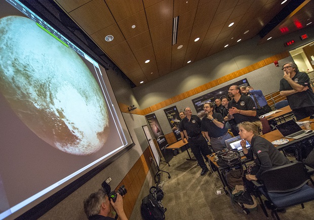 Members of the New Horizons science team react to seeing the spacecraft's last and sharpest image of Pluto before closest approach later in the day, Tuesday, July 14, 2015, at the Johns Hopkins University Applied Physics Laboratory (APL) in Laurel, Maryland. NASA's New Horizons spacecraft was on track to zoom within 7,800 miles (12,500 kilometers) of Pluto on Tuesday. (Bill Ingalls/NASA via AP)