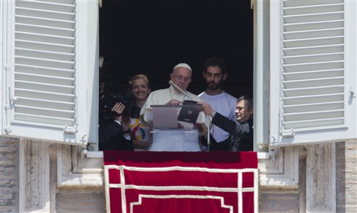 Pope Francis uses a tablet computer to sign himself up for next year’s World Youth Day in Poland, during the Angelus noon prayer he celebrated from the window of his studio overlooking St. Peter's Square at the Vatican, Sunday, July 26, 2015. The pontiff was joined by two young people as he extended an invitation to the world’s Roman Catholic youth to join him in Krakow on July 25-31, 2016.  AP PHOTO/ALESSANDRA TARANTINO