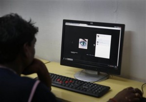 An Indian youth uses the internet at a cyber cafe in Allahabad, India, Monday, Aug.3, 2015. India has ordered Internet service providers to block access to more than 850 adult websites in what the government has described as a way to protect social decency.  AP PHOTO 