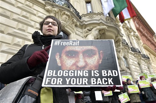FILE - In this Friday, Feb. 6, 2015 file photo, members of the Austrian Greens attend a protest against the detainment of Saudi blogger Raif Badawi in front of the KAICIID in Vienna, Austria. A Saudi blogger sentenced to 10 years in prison and 1,000 lashes for insulting Muslim clerics has won the European Unions prestigious Sakharov Prize for human rights. Raif Badawi was honored with the award as a symbol of the fight for freedom of speech - an announcement greeted with a standing ovation Thursday, Oct, 29, 2015 at the European Parliament assembly in Strasbourg, France. I urge the king of Saudi Arabia to free him, so he can accept the prize, Parliament President Martin Schulz said. (AP Photo/Hans Punz, file)