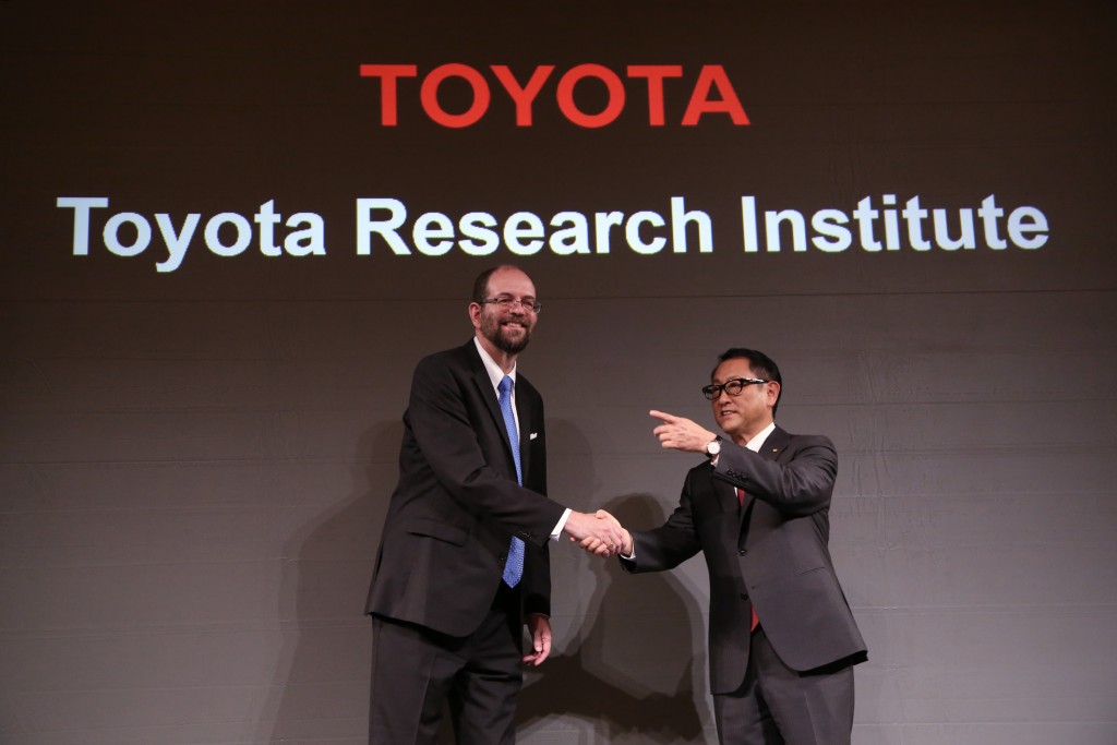 Toyota Motor Corp.'s Executive Technical Advisor Gill Pratt, left, and President Akio Toyoda, right, shake hands during  a press conference on artificial intelligence in Tokyo, Friday, Nov. 6, 2015. Toyota is investing $1 billion in a research company it's setting up in Silicon Valley to develop artificial intelligence and robotics, underlining the Japanese automaker's determination to lead in futuristic cars that drive themselves and apply the technology to other areas of daily life. (AP Photo/Eugene Hoshiko)
