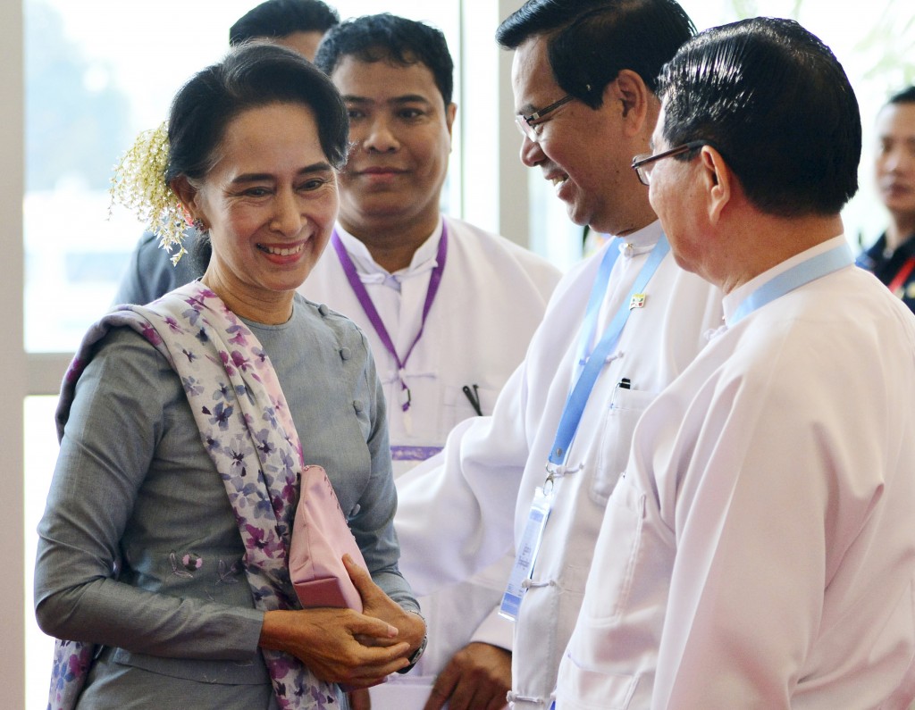 Leader of National League for Democracy party (NLD) Aung San Suu Kyi, left, arrives to deliver a speech in Naypyitaw, Myanmar, Tuesday, Jan. 12, 2016. Aung San Suu Kyi, whose pro-democracy party will take over power in Myanmar from a pro-military government in the next few months, has for the first time participated in official talks to bring peace with the country's fractious ethnic minorities.(AP Photo/Aung Shine Oo)