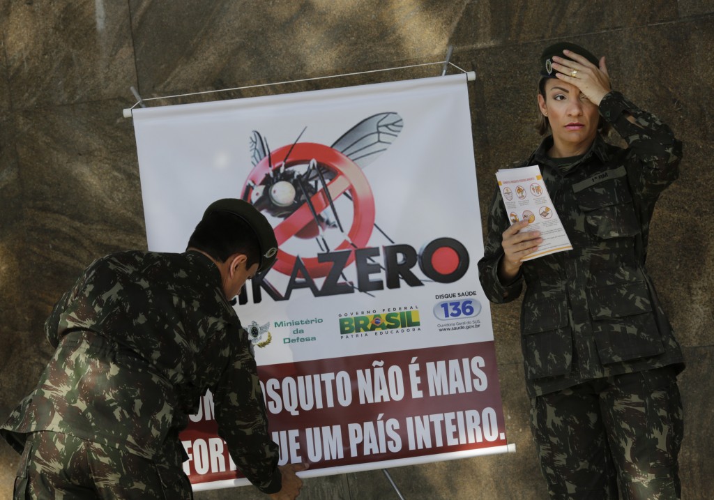 FILE - In this Saturday, Feb. 13, 2016 file photo, army soldiers set up a sign that reads in Portuguese "A mosquito is not stronger than an entire country" at the Central station in Rio de Janeiro, Brazil, as troops across Brazil try to tackle the Zika virus. Scientists may have the first evidence that Zika causes temporary paralysis, according to a new study of patients who developed the rare condition during an outbreak of the virus in Tahiti two years ago. The research was published online Monday, Feb. 29 in the journal, Lancet.  (AP Photo/Silvia Izquierdo, file)