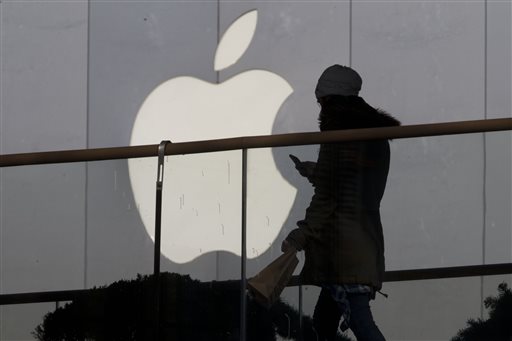 In this Dec. 23, 2013, file photo, a woman using a phone walks past Apple's logo near its retail outlet in Beijing. Even while it fiercely opposes the FBIâ??s demand for help unlocking an encrypted iPhone used in the San Bernardino mass shootings, Apple has never argued that it isnâ??t capable of doing what the government wants. While the FBI may have found an alternative solution in the San Bernardino case, experts say itâ??s almost certain that Apple and other tech companies will keep increasing the security of their products, making it harder or perhaps even impossible for them to answer government demands for customersâ?? data. (AP Photo/Ng Han Guan, File)