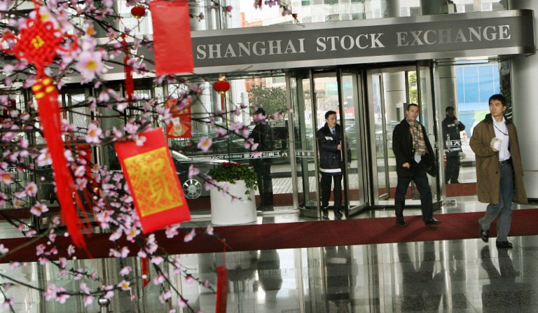 Chinese investors arrive at the Shanghai Stock Exchange as they pass near a blossom tree containing traditional red envelopes containing money for good luck in Shanghai 28 February 2007.  The dramatic one-day wobble in Chinese share prices highlights the tricky task facing regulators as they try to prevent a dangerous bubble in a market that has grown 130 percent in a year. Analysts said that the 27 February 8.84-percent plunge in the Shanghai Composite Index suggested the government may have miscalculated, the sell-off was also partly caused by profit taking after a long period of gains.       AFP PHOTO/Mark RALSTON / AFP PHOTO / MARK RALSTON