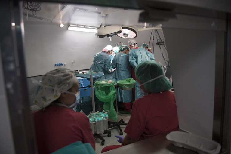 Two nurses look at surgeon XXX and his staff performing a renal transplantation on patient Juan Benito Druet at La Paz hospital in Madrid on February 28, 2017 . Doctors in Spain performed 4,818 transplants on 2016, including 2,994 kidney transplants, according to the health ministry's National Transplant Organisation (ONT). That means there were 43.4 organ donors per million inhabitants last year, a world record, up from 40.2 donors in 2015. By comparison in the United States there were just 28.2 donors per million inhabitants in 2015, in France there were 28.1 donors and in Germany there were 10.9 donors, according to the Council of Europe. Photo by AFP.