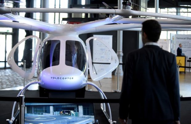 (FILES) In this file photo taken on October 18, 2018, an electric Volocopter 2X by German aircraft manufacturer Volocopter, is on display during the 3rd edition of the "Autonomy and the Urban Mobility Summit" in Paris. - Test flights of a driverless hover-taxi will take place in Singapore next year, a company said, the latest innovation to offer an escape from Asia's mega-jams. (Photo by ERIC PIERMONT / AFP)