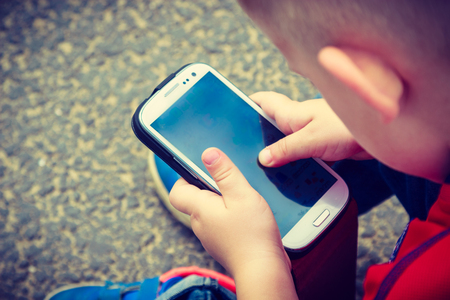 Child playing on smartphone stock