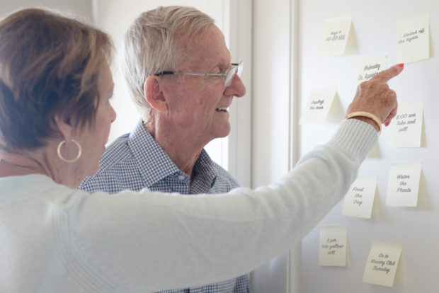 elderly couple looking at sticky notes