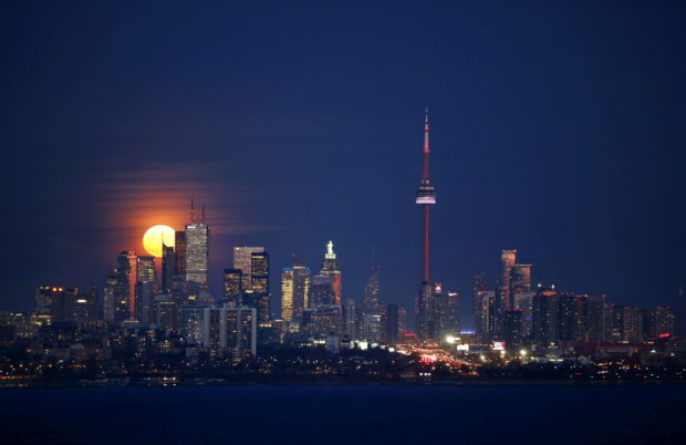 The moon rises behind the skyline and financial district in Toronto, November 25, 2015.    REUTERS/Mark Blinch/File Photo
