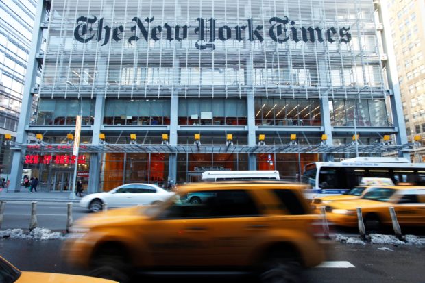 Vehicles drive past the New York Times headquarters in New York, media