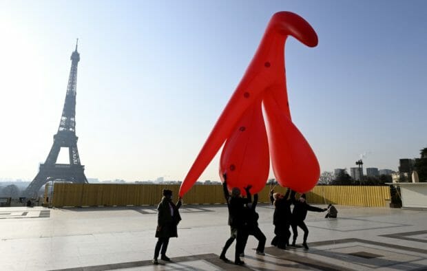 Members of the group "Gang du Clito" carry a five meters high inflatable clitoris to denounce sexual illiteracy to mark the International Women's Day on the Parvis des Droits de l'Homme (Human Rights plaza) facing the Eiffel Tower in Paris on March 8, 2021. (Photo by Stefano RELLANDINI / AFP)