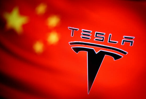 FILE PHOTO: Chinese flag and Tesla logo is seen through a magnifier in this illustration taken January 7, 2021. REUTERS/Dado Ruvic