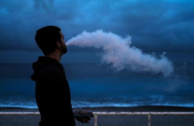 (FILES) In this file photo taken on February 3, 2022, a man smokes an e-cigarette as he walks along the "Promenade des anglais" on the French riviera city of Nice. - Mexico on May 31, 2022, banned sales of electronic cigarettes and other vaping devices because of concerns about their health effects, the government announced. President Andres Manuel Lopez Obrador said it was a "lie" to claim that e-cigarettes are a safe alternative to inhaling tobacco smoke. (Photo by Valery HACHE / AFP)