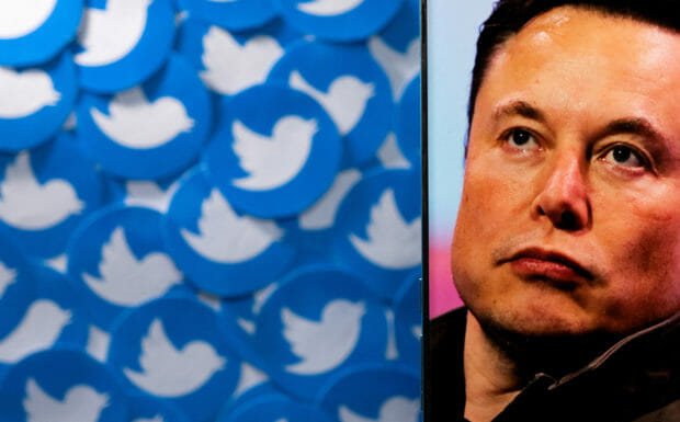 FILE PHOTO: An image of Elon Musk is seen on a smartphone placed on printed Twitter logos in this picture illustration taken April 28, 2022. REUTERS/Dado Ruvic/Illustration/