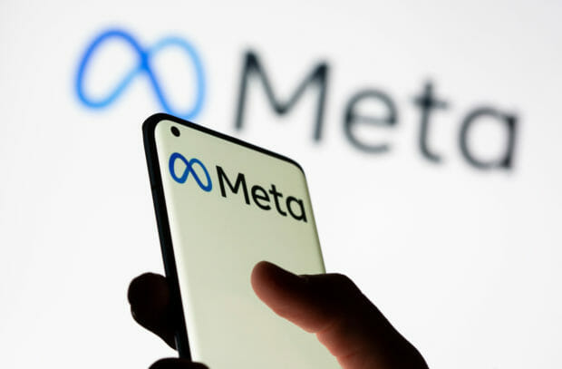 FILE PHOTO: Woman holds smartphone with Meta logo in front of a displayed Facebook's new rebrand logo Meta in this illustration picture taken October 28, 2021. REUTERS/Dado Ruvic/Illustration
