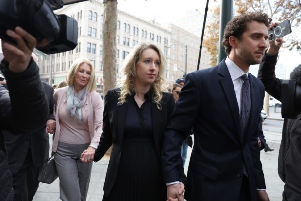 SAN JOSE, CALIFORNIA - NOVEMBER 18: Former Theranos CEO Elizabeth Holmes (C) arrives at federal court with her partner Billy Evans (R) and mother Noel Holmes on November 18, 2022 in San Jose, California. Holmes appeared in federal court for sentencing after being convicted of four counts of fraud for allegedly engaging in a multimillion-dollar scheme to defraud investors in her company Theranos, which offered blood testing lab services.   Justin Sullivan/Getty Images/AFP (Photo by JUSTIN SULLIVAN / GETTY IMAGES NORTH AMERICA / Getty Images via AFP)