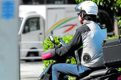 BUILT-IN COOLERS A mangoes out on a motorbike in the streets of Tokyo wearing a jacket with battery-powered built-in fans (one with a circular opening visible on his side) in this photo taken on Aug. 4. —AFP wearable tech heat