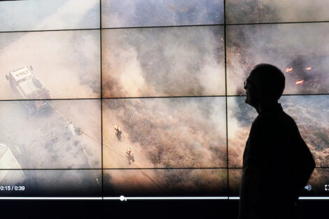 Researcher watching a wildfire in progress on a big screen