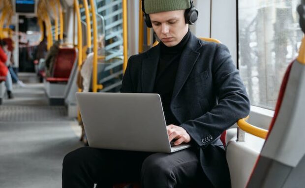 Commuter working on a laptop during travel.