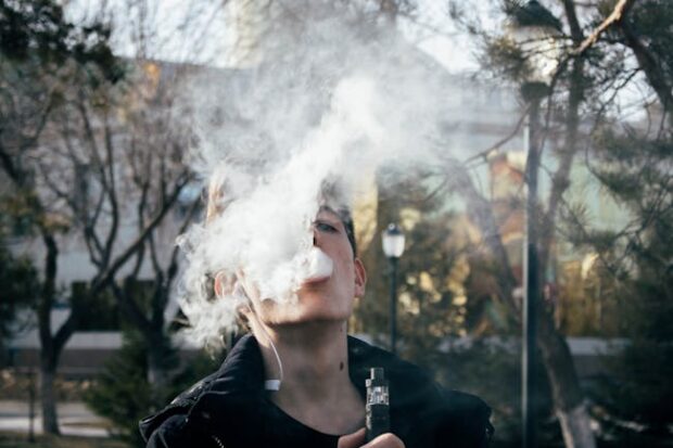 This is a man smoking an e-cigarette.